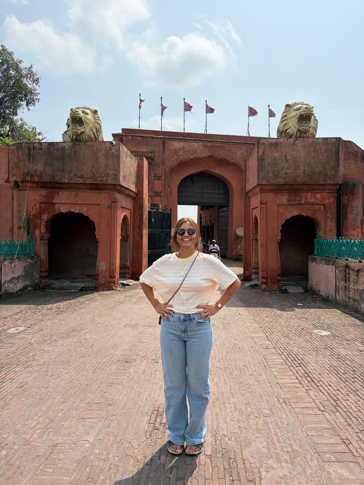 Chandrika smiling in front of an ornate gateway