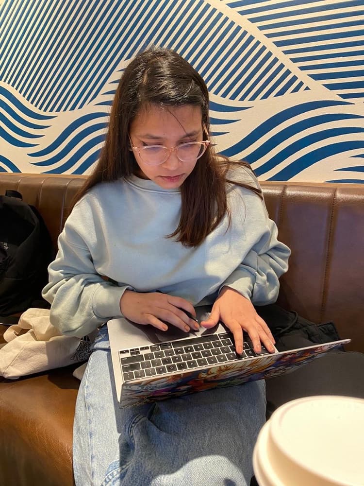 Black and white photograph of Chandrika working on her laptop
